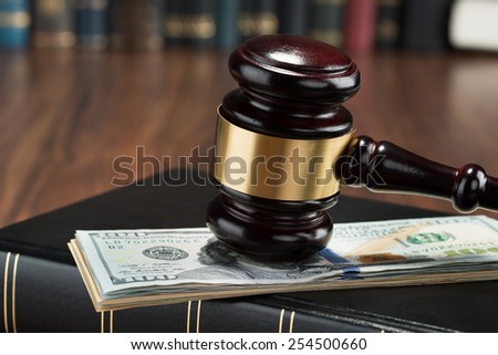 Close-up Of Gavel On A Stack Of American Banknote And Law Book