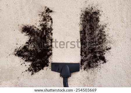 High Angle View Of Vacuum Cleaner Cleaning Dirt On Carpet