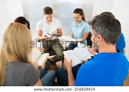 Group Of People Sitting Together Reading Books