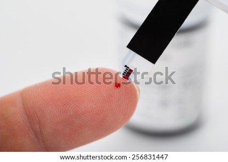 Close-up Of Person Finger Checking The Glucose Level With A Glucometer