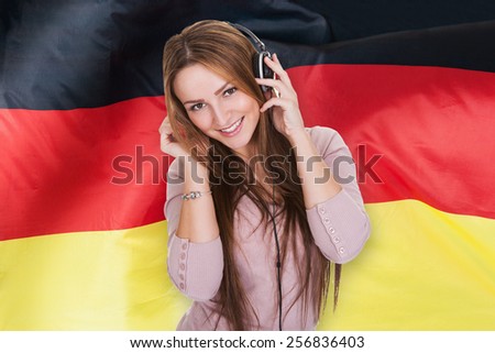Woman Listening German Learning Audiobook In Front Of German Flag