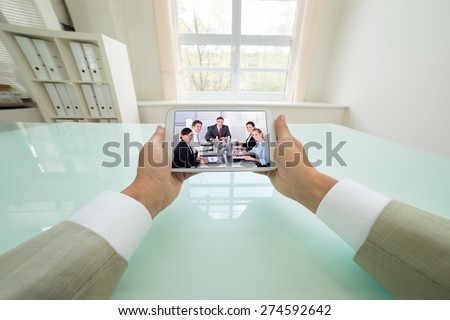 Close-up Of A Businessman Video Chatting With Colleagues On Digital Tablet. Photographer owns copyright for images on screen