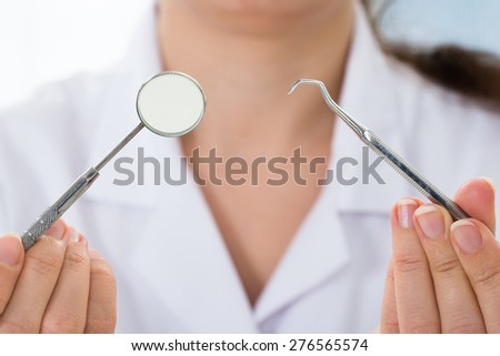 Close-up Of Doctor Holding Dentist Tool In Hand