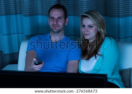 Happy Couple With Remote Control Watching Movie At Home