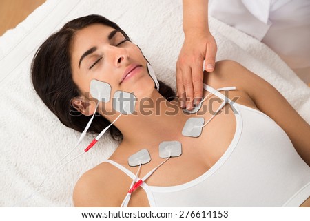 Young Woman Lying With Electrodes On Chest And Face