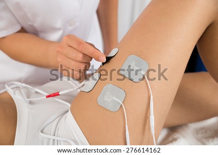 Close-up Of Therapist Placing Electrodes On Woman\'s Thigh