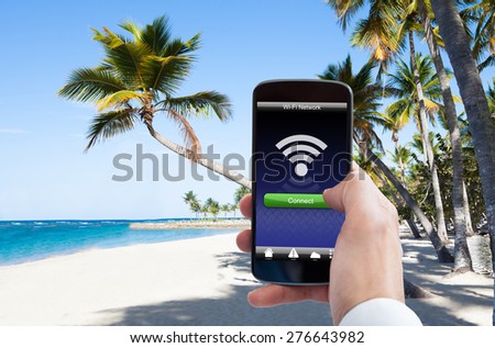 Close-up Of Person Hand With Wifi On Mobile Phone At The Beach