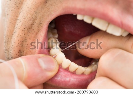 Close-up Photo Of A Man Flossing Teeth