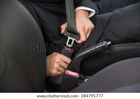 Close-up Of A Man Sitting In Car Fastening Seat Belt 商業照片 © 