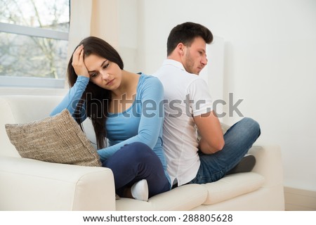 Portrait Of A Displeased Couple Sitting Back To Back On Couch
