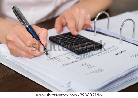 Close-up Of Accountant Doing Calculation With Calculator In Office