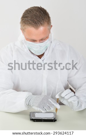 Young Man Wearing Mask And Glove Repairing Harddisk With Screwdriver