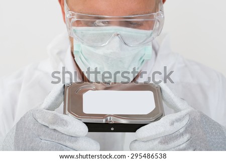 Young Man With Mask And Protective Glasses Holding Harddisk