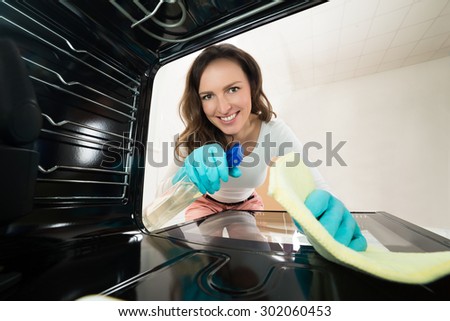 Young Happy Woman Cleaning View From Inside The Oven