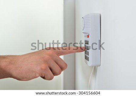 Close-up Of Person Hand Pressing Button On Door Security System