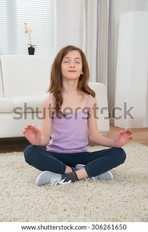 Girl In Sportswear Doing Meditation In Living Room