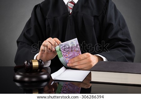 Close-up Of Judge Counting Euro Banknote In Courtroom