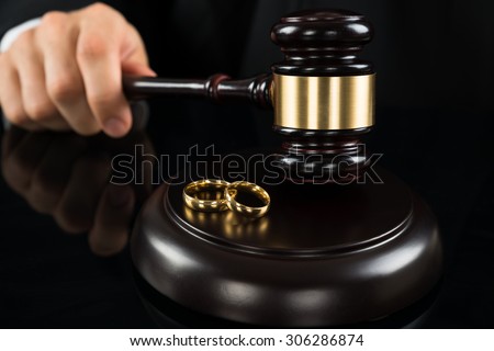 Close-up Of Judge Hands Hitting Gavel With Golden Rings At Desk