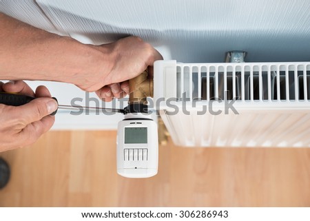 Close-up Photo Of Technician Installing Digital Thermostat Using Screwdriver