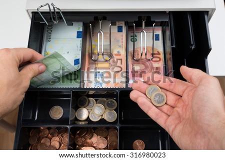 Close-up Of Person Hands With Money Over Cash Register