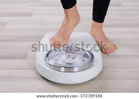 Low Section Of Person Standing On Weighing Scale Foto d'archivio © 