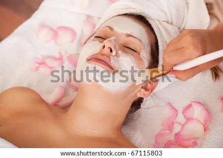 Young women getting facial mask. Spa studio shot