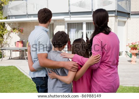 Buying new home - Family standing in front of their new house