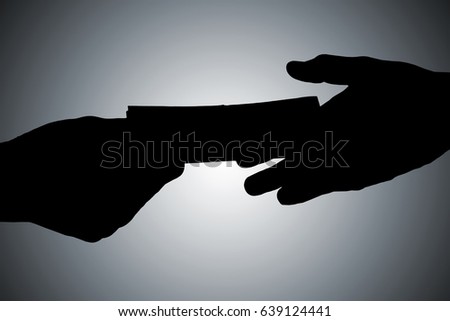 Silhouette Of Hands Giving Bribe Against Gray Background 商業照片 © 