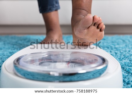 Close-up Of A Human Foot Stepping On Weighing Scale Stock foto © 