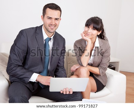 Two business people sitting in the couch discussing