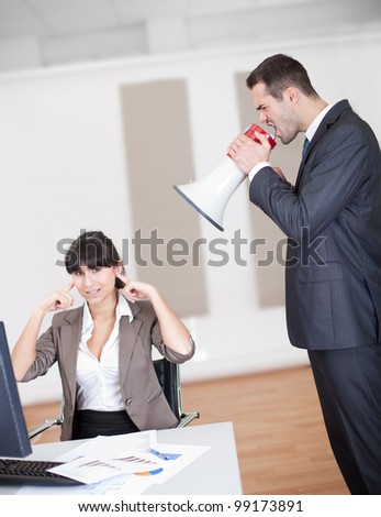 Angry businessman screaming at employee at the office in megaphone