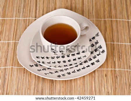 Cup of tea in chinese cup on bamboo mat background