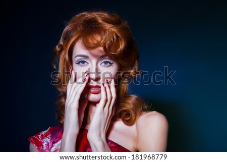 Beautiful woman touching face, clean skin, red hairs, red nails. White isolated background.