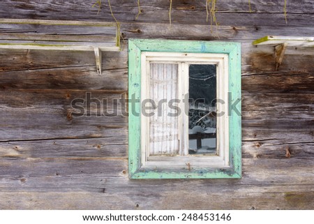 Window with a green border in a wooden wall