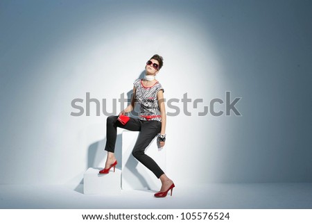 fashionable model in sunglasses on the wooden cube.