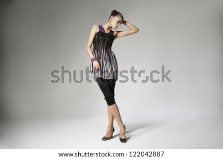Full body casual young woman standing posing on gray background