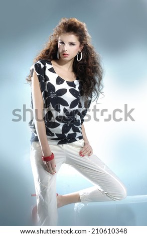 fashionable woman posing near the cube on gray background