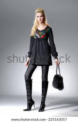 full-length Beautiful Young Model holding bag posing in light background