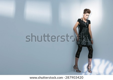 Full length portrait fashion model standing posing on light background
