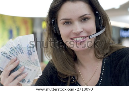 Secretary in call center answering a call with hands-free having lot of money in hand
