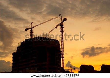 House building crane silhouettes agianst red evening skyset