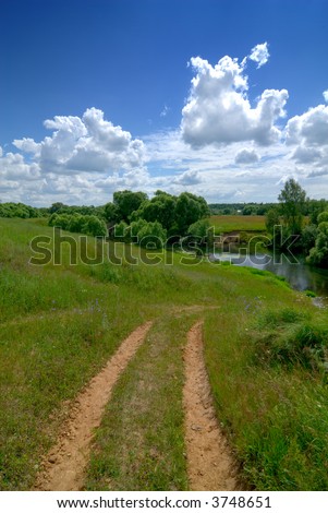 Serene rural landscape. Road river and clear sky