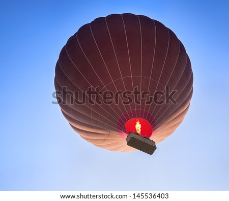 Silhouette of balloon on blue sky background, landing at Sunrise