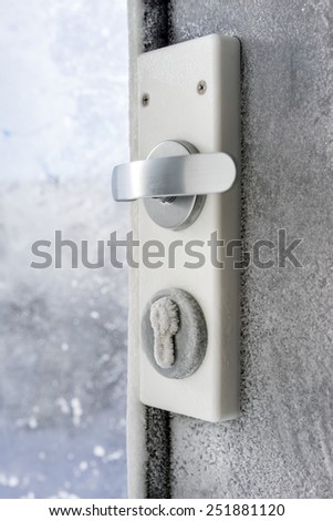 Glass doors with padlock covered with hoarfrost ice crystals in frosty day