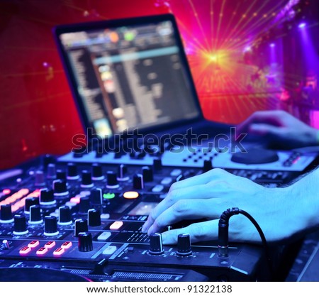 Dj playing the track in the nightclub at a party. In the background laser light show