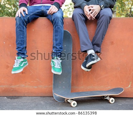 Foto Bild Zwei junge Skater, die mit den Köpfen auf ihren Boards ruhen.