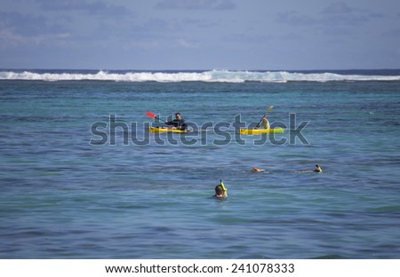 RAROTONGA, COOK ISLANDS - FEBRUARY 5, 2009:  People sea kayaking and snorkeling in tropical lagoon of Rarotonga, Cook Islands.