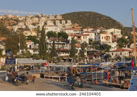 KAS, TURKEY - OCTOBER 15, 2009: Picturesque Harbor of the village Kas in Turkey. Boat and diving tours for tourists starts here. After work people are relaxing at sunset.
