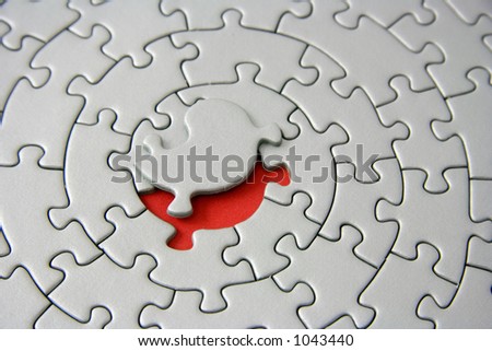 grey jigsaw with the missing piece laying above the red space - pieces fitting together in form of a spiral