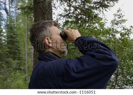 park ranger watching closely wildlife - with his field glass